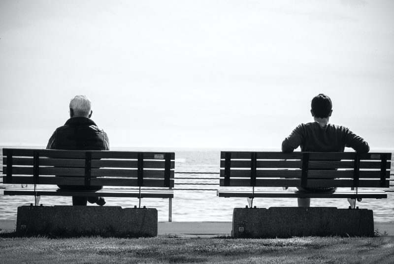 deux hommes assis de dos qui regardent la mer; un plus jeune et l'autre plus âgé